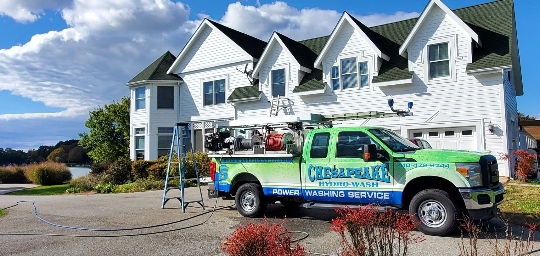 Chesapeake Hydro-Wash truck positioned beside a white Maryland home for house washing